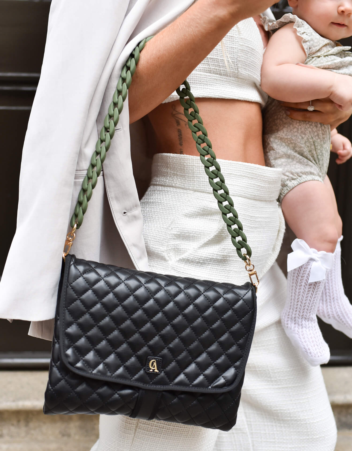 professional mom carrying a baby and a stylish diaper bag in her arm